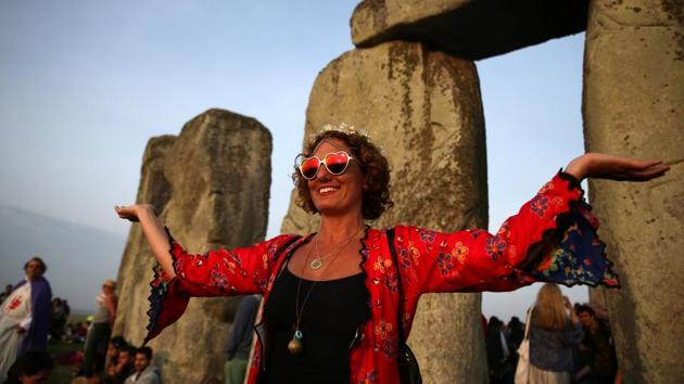 A woman watches the sun rise at the stones of the Stonehenge monument. Believed to have stood in the same spot since 3,000 to 2,000 BC they are positioned to align with the sunrise on the two annual solstices. (REUTERS)