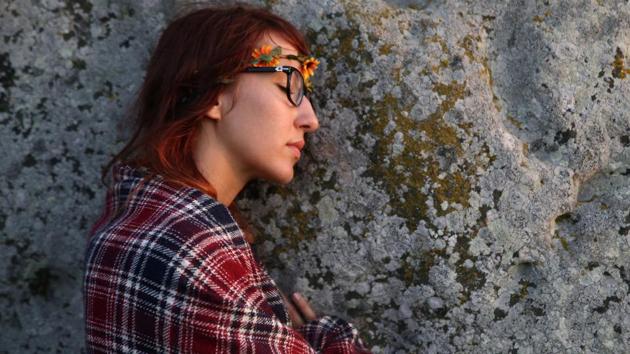 A woman leans against one of the stones of the Stonehenge monument on the Summer Solstice. (REUTERS)