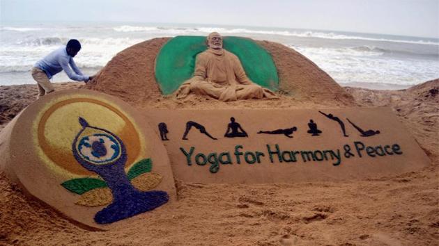 Sand artist Sudarsan Patnaik creates a sand sculpture of Prime Minister Narendra Modi with the message ‘Yoga for Harmony & Peace’ at Odisha’s Puri beach on Tuesday. (PTI photo) Sand artist Sudarsan Patnaik creates a sand sculpture of Prime Minister Narendra Modi with the message ‘Yoga for Harmony & Peace’ at Odisha’s Puri beach on Tuesday. (PTI photo)