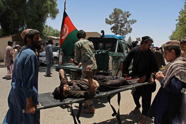 Afghan men carry a victim of the powerful car bomb in Lashkar Gah.(AFP)