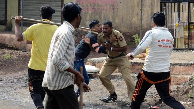 A policeman tries to escape as villagers attack him in Nevali. (Rishikesh Choudhary/HT PHOTO) 