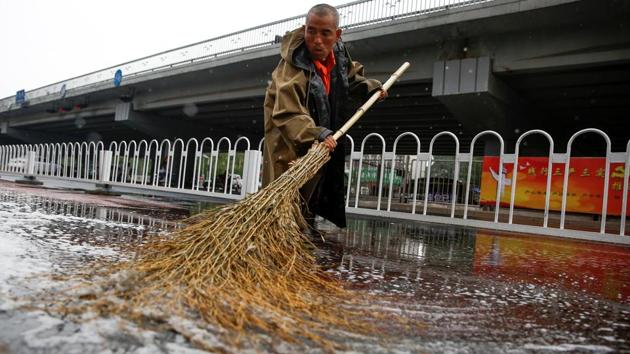 A city cleaner sweeps a street after rain flooded a cycling path in Beijing, China, June 13, 2017. (REUTERS) A city cleaner sweeps a street after rain flooded a cycling path in Beijing, China, June 13, 2017. (REUTERS)