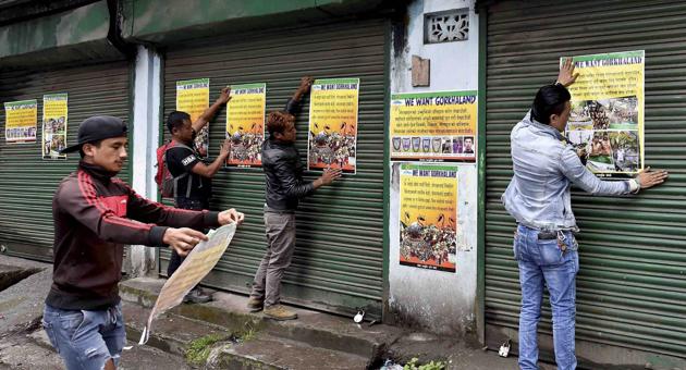 Darjeeling: Activists of GJM paste the party posters on the shutters of close shops during GJM indefinite strike near DM office in Darjeeling on Wednesday. PTI Photo by Ashok Bhaumik (PTI6_21_2017_000360B) (PTI) Darjeeling: Activists of GJM paste the party posters on the shutters of close shops during GJM indefinite strike near DM office in Darjeeling on Wednesday. PTI Photo by Ashok Bhaumik (PTI6_21_2017_000360B) (PTI)
