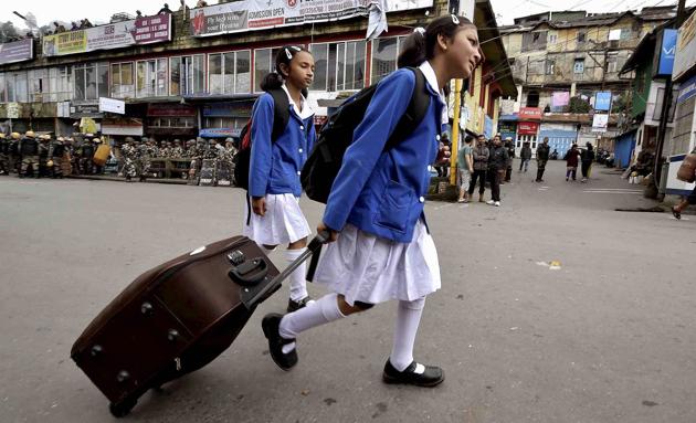 School students walk past security personnel guarding in a street during GJM indefinite strike in Darjeeling, West Bengal on June 21, 2017. (Ashok Bhaumik /PTI) School students walk past security personnel guarding in a street during GJM indefinite strike in Darjeeling, West Bengal on June 21, 2017. (Ashok Bhaumik /PTI)