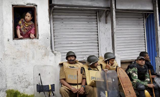 Security personnel sit guard as a woman looks out of a window in Darjeeling, West Bengal. As the Gorkha Janmukti Morcha (GJM) indefinite strike completes a week, normal life continues to suffer amid protests, calls for the separate state of Gorkhaland still ringing and the deployment of paramilitary personnel in the hill town. While an all-party meet is scheduled on June 22, 2017 to address the unrest, chief minister Mamata Banerjee’s announced absence has opposition parties unsure about the impact of the gesture. (Ashok Bhaumik/PTI) Security personnel sit guard as a woman looks out of a window in Darjeeling, West Bengal. As the Gorkha Janmukti Morcha (GJM) indefinite strike completes a week, normal life continues to suffer amid protests, calls for the separate state of Gorkhaland still ringing and the deployment of paramilitary personnel in the hill town. While an all-party meet is scheduled on June 22, 2017 to address the unrest, chief minister Mamata Banerjee’s announced absence has opposition parties unsure about the impact of the gesture. (Ashok Bhaumik/PTI)