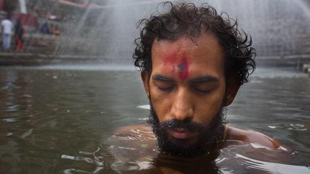 An Indian devotee prays as he takes a dip in Saubhagya Kunda, a holy pond at Kamakhya temple during the Ambubachi festival. (AP) An Indian devotee prays as he takes a dip in Saubhagya Kunda, a holy pond at Kamakhya temple during the Ambubachi festival. (AP)