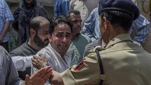 A police officer comforts a wailing relative of Mohammad Ayoub Pandith, a policeman who was beaten to death, during a wreath laying ceremony at the police headquarters in Srinagar.(AP)
