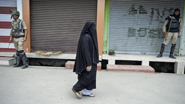 A woman walks past shops during a curfew in Srinagar on Friday, a day after Mohammad Ayub Pandith was beaten to death at Jama mosque.(AFP PHOTO) A woman walks past shops during a curfew in Srinagar on Friday, a day after Mohammad Ayub Pandith was beaten to death at Jama mosque.(AFP PHOTO)