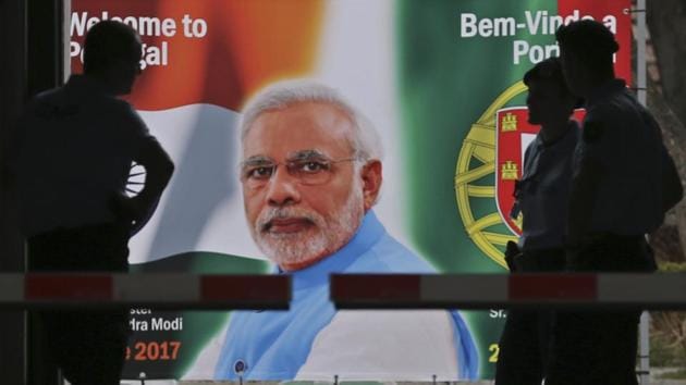 Police stand by a welcome poster showing Prime Minister Narendra Modi at the entrance of the Necessidades Palace, the Portuguese Foreign Ministry in Lisbon, Portugal.(AP Photo)