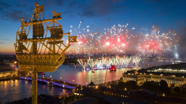 An aerial view of light show and firework with a brig with scarlet sails, right, floating on the Neva River . The city landmark, weathercock in the form of a ship fixed atop a spire of the Admiralty building is in the foreground. (Dmitri Lovetsky / AP)