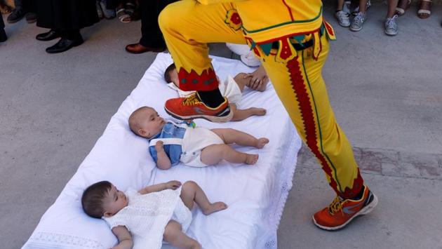 A man dressed up as the devil jumps over babies lying on a mattress in the street during 'El Colacho', the 'baby jumping festival' in the village of Castrillo de Murcia, near Burgos on June 18, 2017. Baby jumping (El Colacho) is a traditional Spanish practice dating back to 1620 that takes place annually to celebrate the Catholic feast of Corpus Christi. During the act - known as El Salto del Colacho (the devil's jump) or simply El Colacho - men dressed as the Devil jump over babies born in the last twelve months of the year who lie on mattresses in the street. (Cesar Manso/AFP)