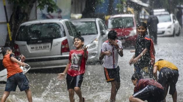 Children play in a waterlogged street after heavy rainfall at Hindamata on Sunday.(Kunal Patil/HT Photo)