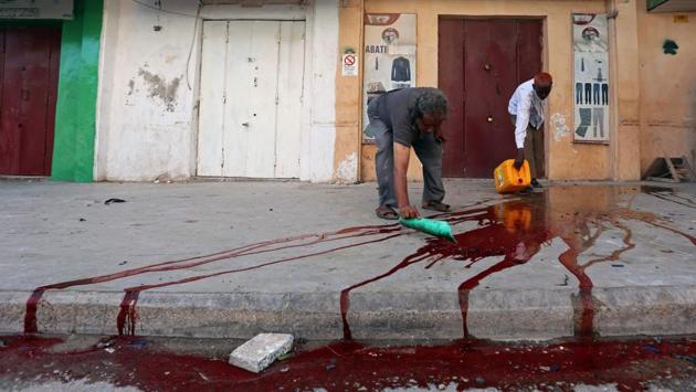 Civilians clean blood from unidentified people injured at the scene of an explosion near Waberi police station station in Mogadishu, Somalia on June 22, 2017. (Feisal Omar/REUTERS)