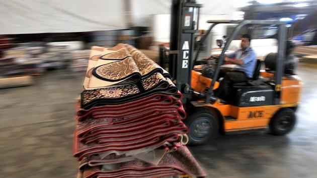 An employee transfers carpets from one section to another at a factory in Bari Brahmana industrial area on Sunday. (Nitin Kanotra/HT Photo)