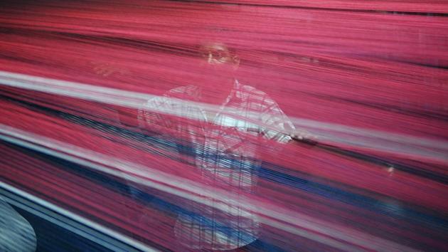 An employee arranges threads in a carpet weaving machine at a factory in the Bari Brahmana industrial area on Sunday. (Nitin Kanotra/HT Photo)