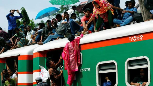 A woman helps another woman to get atop of an overcrowded passenger train as they travel home to celebrate Eid al-Fitr festival at a railway station in Dhaka, Bangladesh on June 23, 2017. (Mohammad Ponir Hossain/REUTERS)