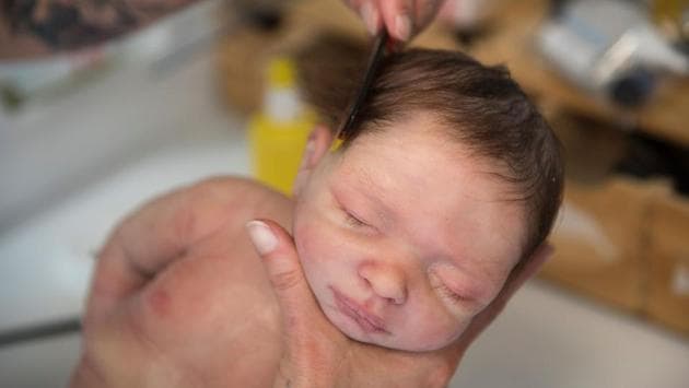 A worker combs a silicone lifelike baby-doll at the Clon Factory in the Spanish Basque city of Leioa on June 20, 2017. (Ander Gillenea/AFP)