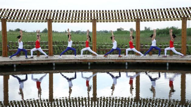 Yoga enthusiasts practice yoga at a wetland park on International Yoga Day, in Zhangye, China on June 21, 2017. (REUTERS)