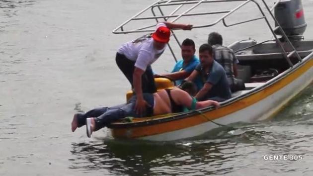 People on a boat rescue passengers of a sinking tourist ferry (not pictured) in the Guatape reservoir in Colombia June 25, 2017 in this still image taken from video obtained from social media. (Reuters) People on a boat rescue passengers of a sinking tourist ferry (not pictured) in the Guatape reservoir in Colombia June 25, 2017 in this still image taken from video obtained from social media. (Reuters)