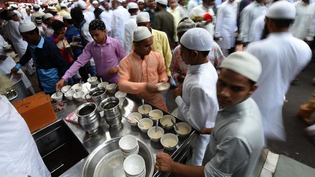 Muslims serve ‘seviyan’, a sweet vermicelli dish, after offering prayers during Eid al-Fitr at the Jama Masjid mosque. (Prakash Singh/ AFP)