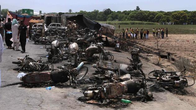 Pakistan army soldiers stands guard while rescue workers examine the site of an oil tanker explosion at a highway near Bahawalpur of Pakistan on Sunday. (AP) Pakistan army soldiers stands guard while rescue workers examine the site of an oil tanker explosion at a highway near Bahawalpur of Pakistan on Sunday. (AP)