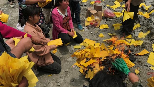 Relatives of victims burn incense and paper money to mourn their dead relatives at the site of a landslide in Sichuan Province. (REUTERS) Relatives of victims burn incense and paper money to mourn their dead relatives at the site of a landslide in Sichuan Province. (REUTERS)