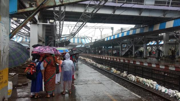 Commuters wait for the train in the rain at Kurla station. (HT Photo) Commuters wait for the train in the rain at Kurla station. (HT Photo)