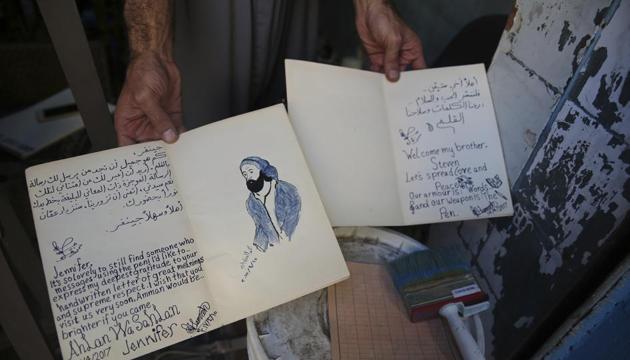 Hamzeh AlMaaytah shows two of many letters he handwrites himself in response to text or Facebook messages, at his Mahall al-Maa bookstore, in Jordan's capital, Amman. (AP) Hamzeh AlMaaytah shows two of many letters he handwrites himself in response to text or Facebook messages, at his Mahall al-Maa bookstore, in Jordan's capital, Amman. (AP)