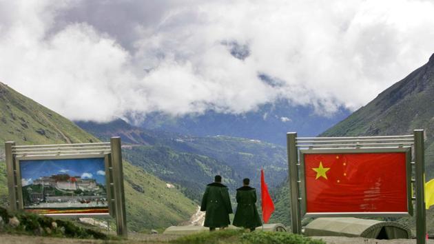 Chinese army officers oversee preparations as they stand between pictures of the Patola Palace, left, and the Chinese flag, on the Chinese side of the international border at Nathula Pass, in northeastern Indian state of Sikkim. (AP) Chinese army officers oversee preparations as they stand between pictures of the Patola Palace, left, and the Chinese flag, on the Chinese side of the international border at Nathula Pass, in northeastern Indian state of Sikkim. (AP)