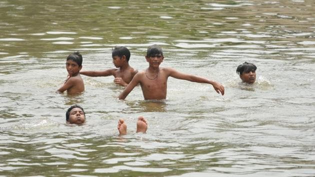 Children swimming in Bist Doab Canal at Jalandhar on Tuesday. (Pardeep Pandit/HT Photo)