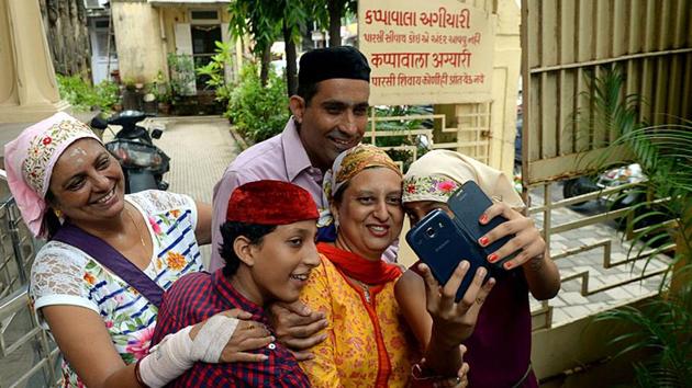 A Parsi family takes a photograph on their mobile phones outside a Fire Temple in Mumbai(AFP) A Parsi family takes a photograph on their mobile phones outside a Fire Temple in Mumbai(AFP)