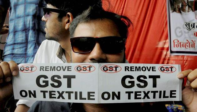 A man holds a poster with an anti-GST message printed on it during a sit-in by traders protesting the soon-to-be-implemented tax regime, in Surat. (PTI) A man holds a poster with an anti-GST message printed on it during a sit-in by traders protesting the soon-to-be-implemented tax regime, in Surat. (PTI)