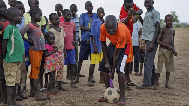 A refugee boy pumps up an old soccer ball, in the Bidi Bidi refugee settlement in northern Uganda.  (Ben Curtis / AP) 