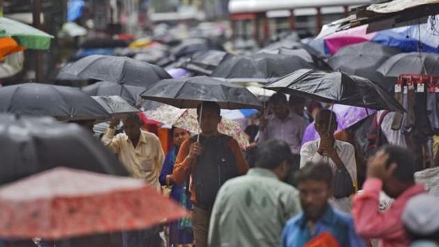 People shield themselves under umbrellas at Bhandup.(Pratik Chorge/HT) People shield themselves under umbrellas at Bhandup.(Pratik Chorge/HT)