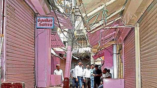 Shopkeepers sit around in the closed Banarasi Saree Bazar during a bandh called against GST in Varanasi on Wednesday.(HT)