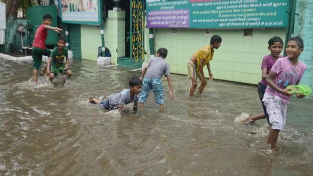 Children playing on a waterlogged street in Amritsar. (Sameer Sehgal/HT)
