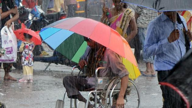 A man uses an umbrella to shield himself from the heavy rain. (HT File) A man uses an umbrella to shield himself from the heavy rain. (HT File)