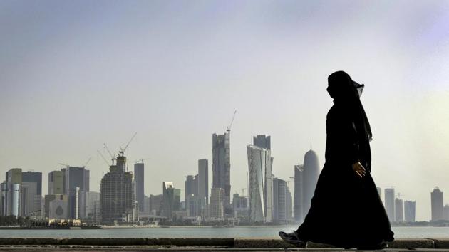 A Qatari woman walks in front of the city skyline in Doha, Qatar. (AP File Photo)