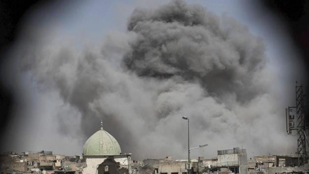 A bomb explodes behind the al-Nuri mosque complex, as seen through a hole in the wall of a house, as Iraqi Special Forces move toward Islamic State militant positions in the Old City of Mosul on Thursday. (AP Photo) A bomb explodes behind the al-Nuri mosque complex, as seen through a hole in the wall of a house, as Iraqi Special Forces move toward Islamic State militant positions in the Old City of Mosul on Thursday. (AP Photo)