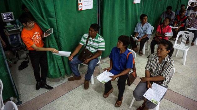 A health worker takes registration papers from a patient during a Cholangiocarcinoma Screening and Care Program event in the northeastern Thai province of Kalasin. While some have already started cooking the fish to kill the parasites, a large number of people still simply shrug off the dangers and say their fate has already been fixed, a common belief in the Buddhist nation where karma can dictate decisions. (Lillian Suwanrumpha/AFP) A health worker takes registration papers from a patient during a Cholangiocarcinoma Screening and Care Program event in the northeastern Thai province of Kalasin. While some have already started cooking the fish to kill the parasites, a large number of people still simply shrug off the dangers and say their fate has already been fixed, a common belief in the Buddhist nation where karma can dictate decisions. (Lillian Suwanrumpha/AFP)