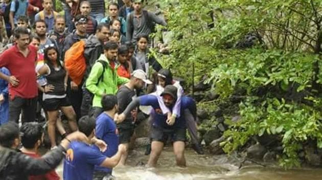 A group of 55, stuck at Devkund between two streams of the Kundalika river, was rescued after a six-hour operation.(HT) A group of 55, stuck at Devkund between two streams of the Kundalika river, was rescued after a six-hour operation.(HT)