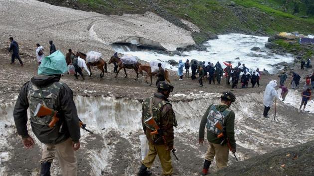 Amarnath pilgrims, accompanied by security personnel, proceed towards the holy cave shrine at Chandanwari in south Kashmir on Thursday. (PTI) Amarnath pilgrims, accompanied by security personnel, proceed towards the holy cave shrine at Chandanwari in south Kashmir on Thursday. (PTI)