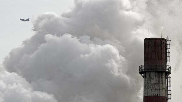 In this Feb. 28, 2017 file photo, a passenger airliner flies past steam and white smoke emitted from a coal-fired power plant in Beijing. (AP) In this Feb. 28, 2017 file photo, a passenger airliner flies past steam and white smoke emitted from a coal-fired power plant in Beijing. (AP)