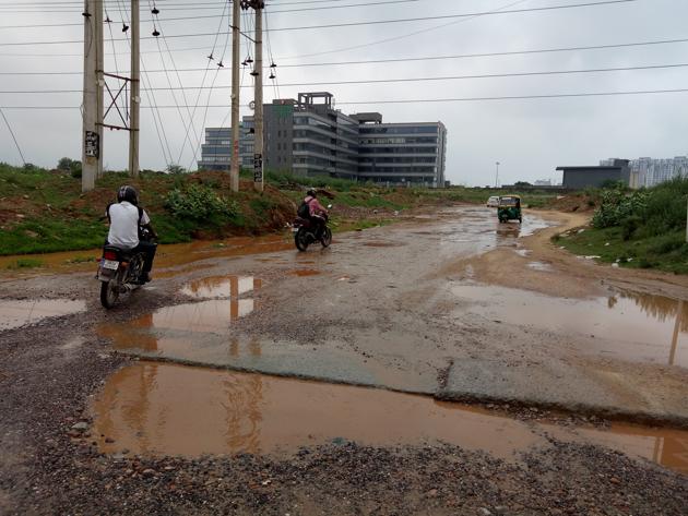 The road connecting Sector 65 to Golf Course Road is riddled with potholes.(Leena Dhankhar/HT PHOTO)