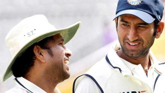 Sachin Tendulkar and Cheteshwar Pujara share a light moment during the cricketing great’s playing days.(PTI)