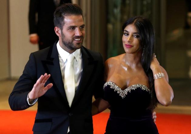 Lionel Messi's former Barcelona FC teammate Cesc Fabregas and his wife Daniella Semaan pose for photographers. (REUTERS)