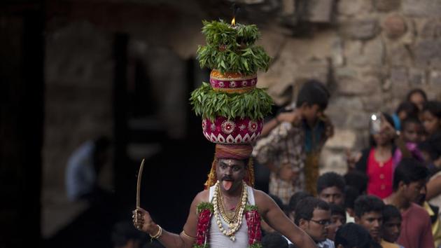 A man dances, balancing on his head a decorated pot filled with cooked rice as an offering to goddess Kali, at the Golconda Fort during the Bonalu festival in Hyderabad, Telangana. Bonalu is a month-long Hindu folk festival of the Telangana region dedicated to Kali, the Hindu goddess of destruction. (Mahesh Kumar A. / AP)