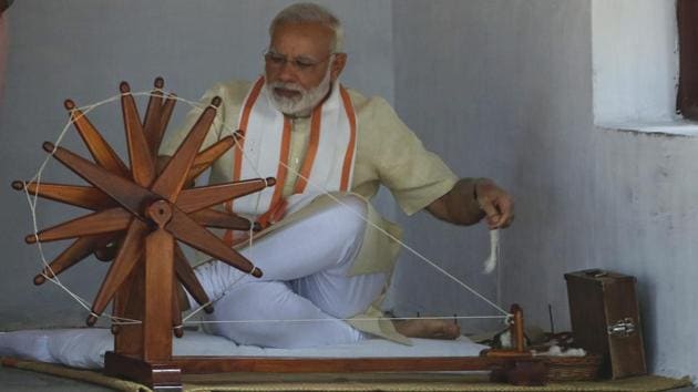 Indian prime minister Narendra Modi tries his hands at the spinning wheel during his visit to Gandhi Ashram or Sabarmati Ashram in Ahmadabad, Gujarat. (Ajit Solanki / AP)