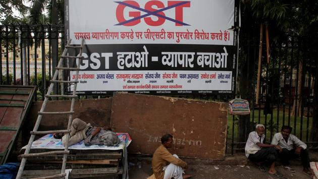Labourers sit next to a banner after a protest against the implementation of the goods and services tax (GST) on textiles, in New Delhi. (Reuters Photo) Labourers sit next to a banner after a protest against the implementation of the goods and services tax (GST) on textiles, in New Delhi. (Reuters Photo)