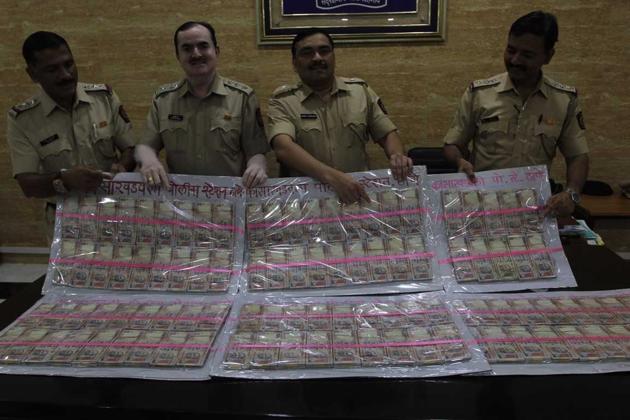 Policemen display the seized notes(HT photo)